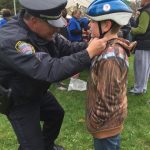 officer helping with helmet