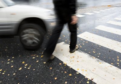 pedestrian in crosswalk near automobile