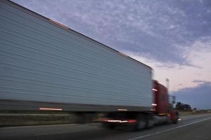 semi-truck-blurry-driving-by-highway