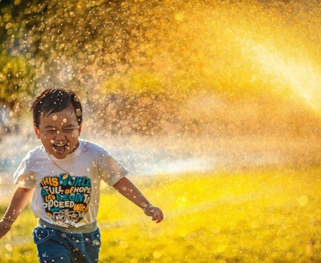 child-running-through-sprinkler