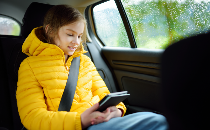 child riding in the back seat, passenger in a motor vehicle