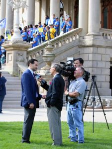 Steve Sinas being interviewed in front of Michigan capitol building